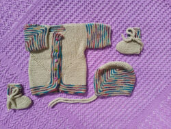 hand knit beige baby set with multicoloured details